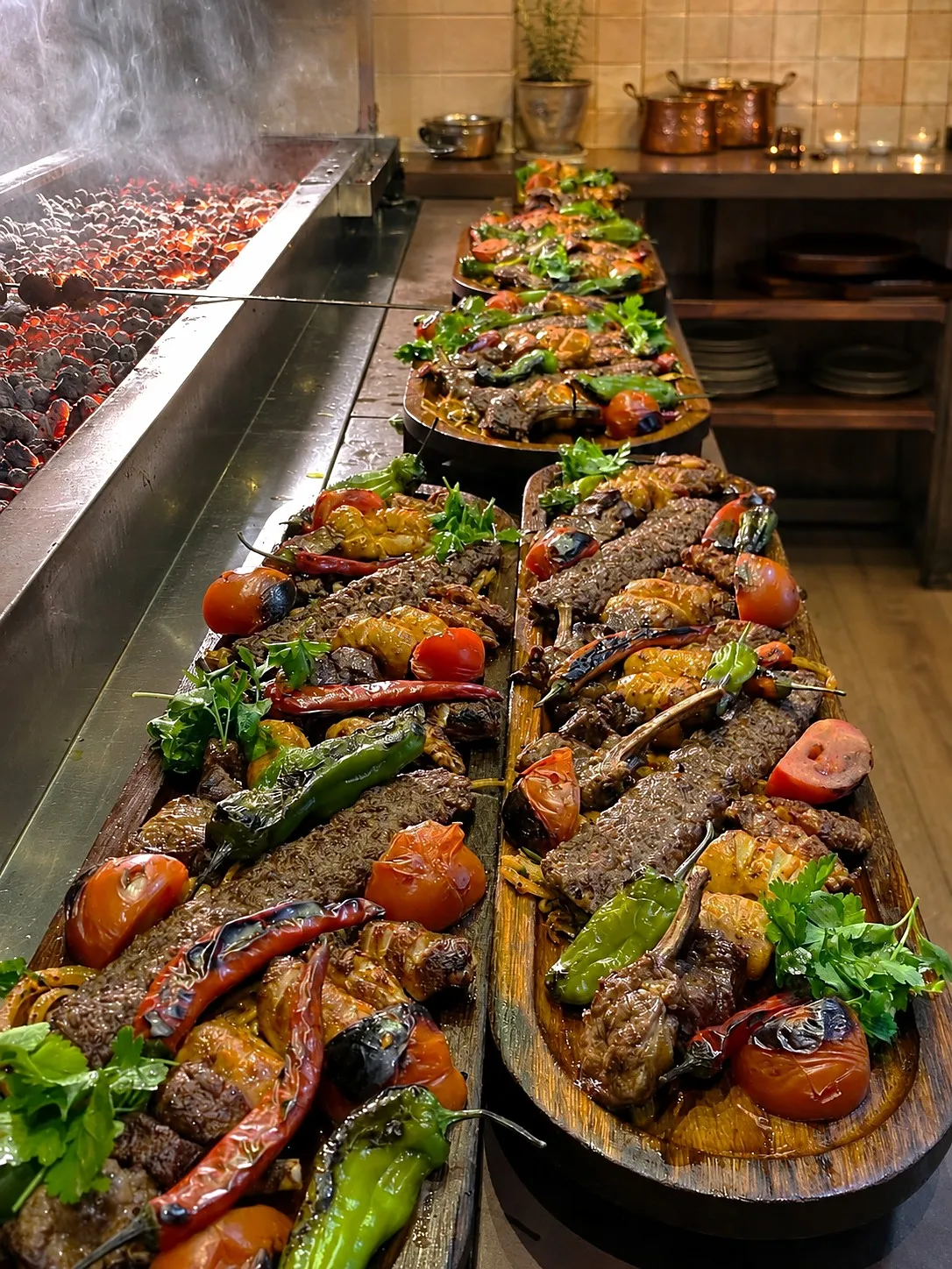 The long charcoal grill at Luma, glowing coals and skewers